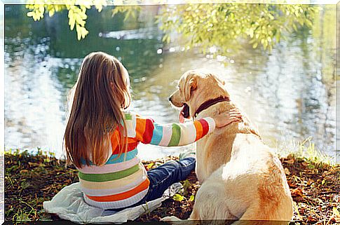 little girl with dog at the lake 